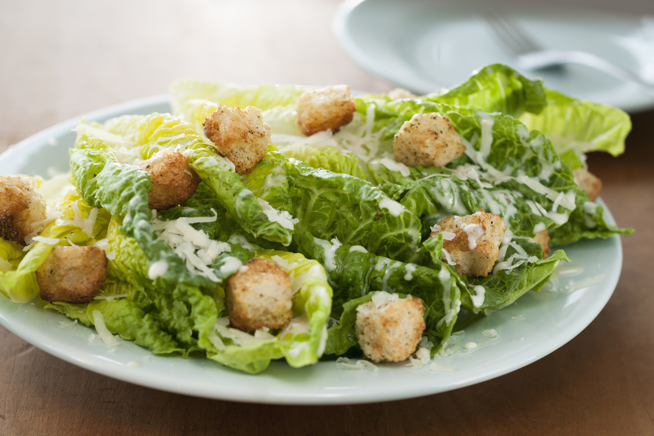 a Caesar salad topped with croutons and cheese