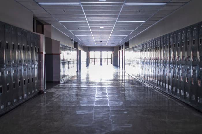 dark empty hallway lined with lockers in a school