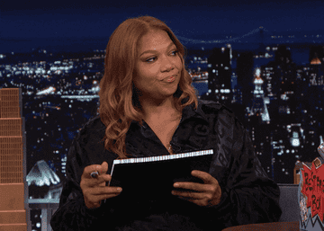 GIF of Queen Latifah starting to write something on a pad