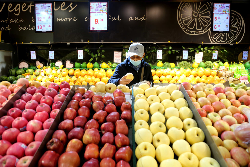 A man picking out produce in a grocery store