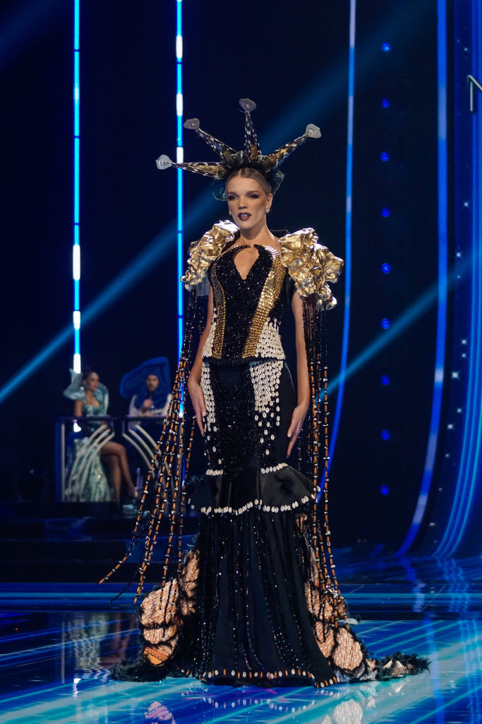 An ornate, beaded gown with train and spiked headgear