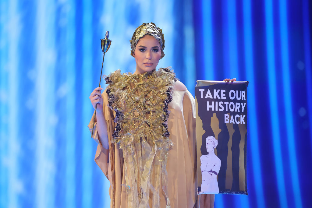 A gown with an ornate front, and she&#x27;s carrying a &quot;Take our history back&quot; scroll and a wand