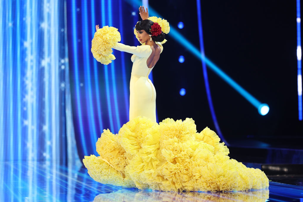 A straight, deep-back yellow flamenco gown with flared bottom and flared sleeves