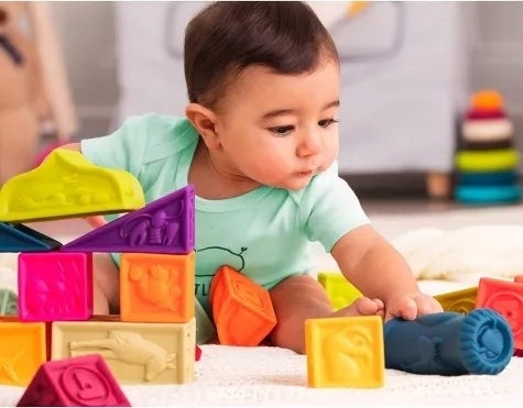 A baby plays with soft blocks