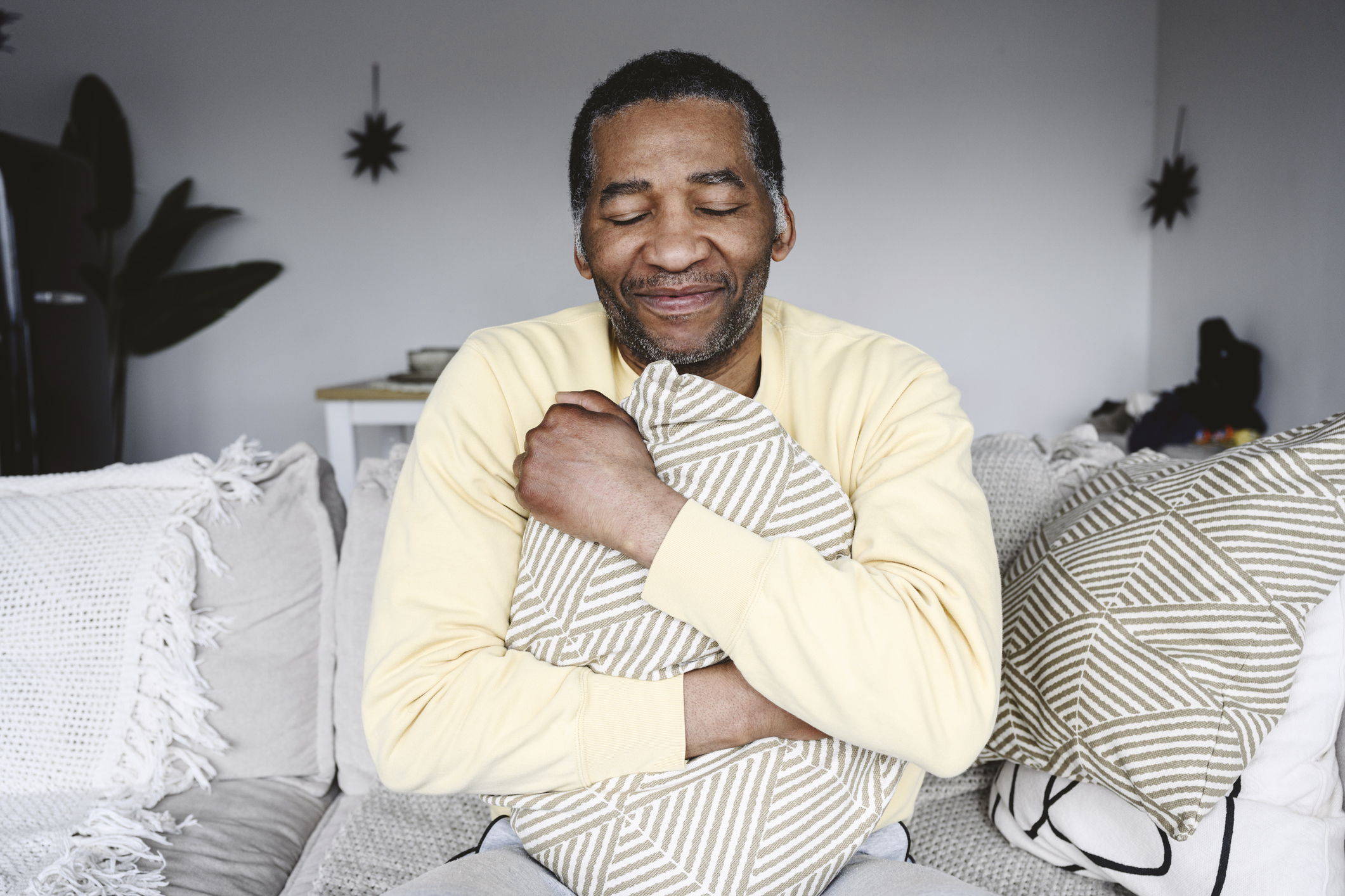 A man smiling as he hugs his pillow