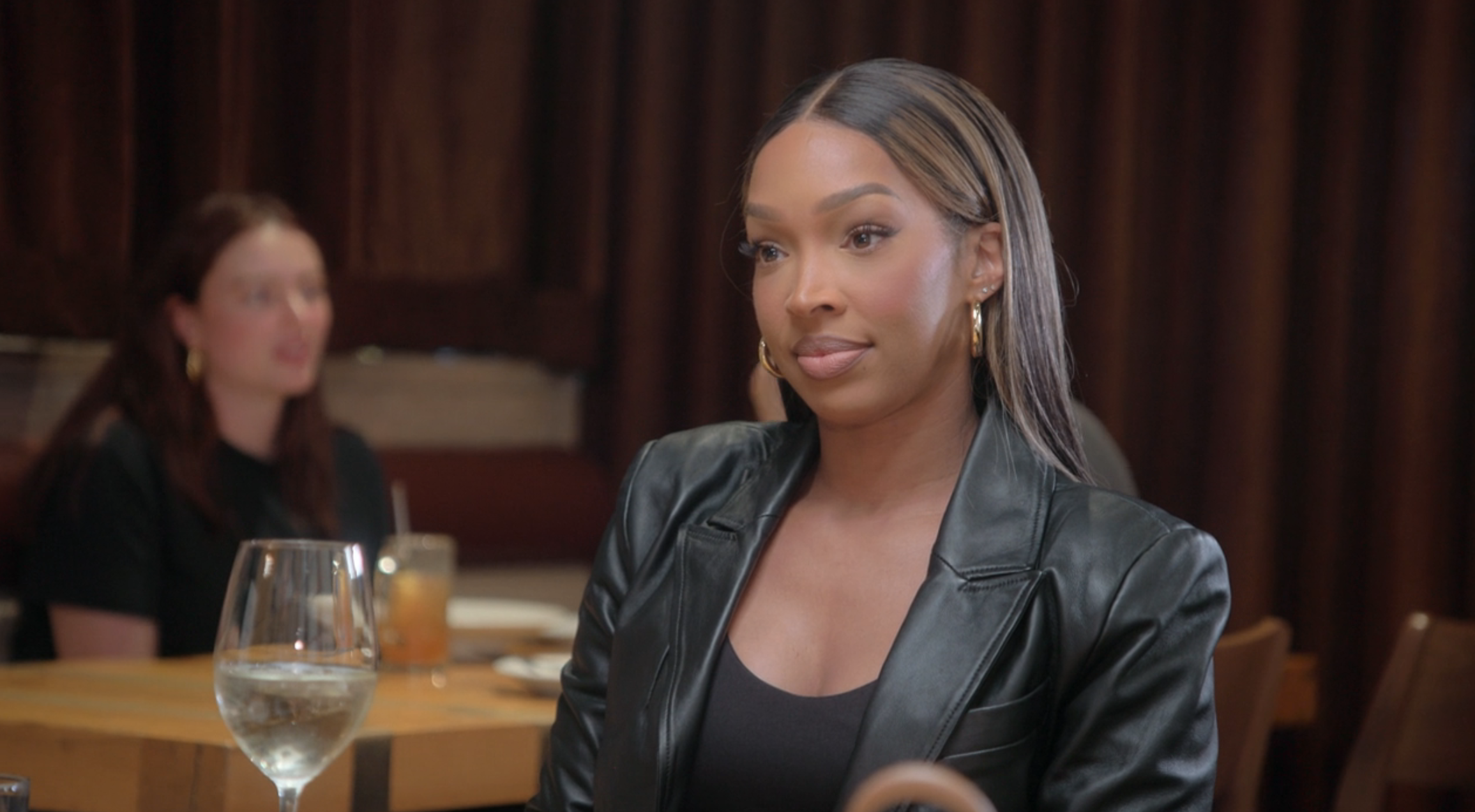 Close-up of Malika sitting at a table