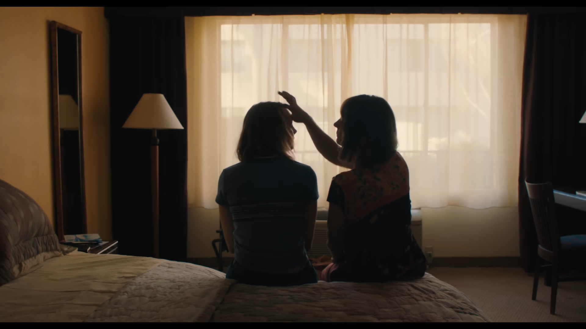 Lady bird and Marion sit on a bed together in the movie "Lady Bird"