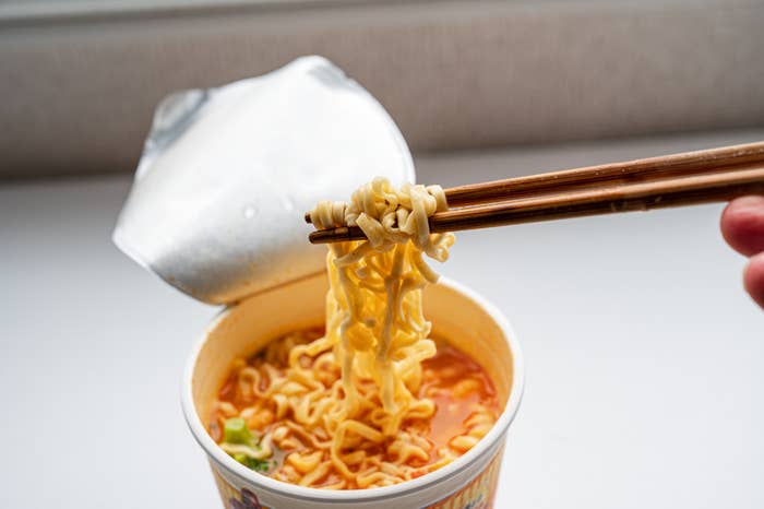 A cup of noodles with chopsticks in them
