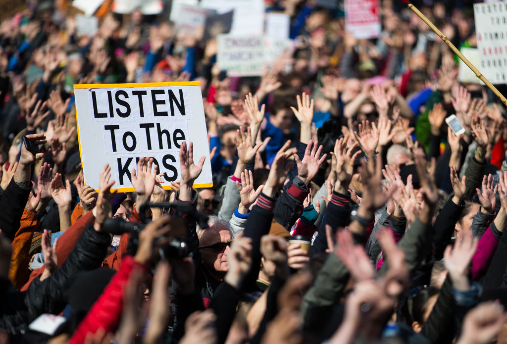A rally with a sign raised that says &quot;Listen to the kids&quot;