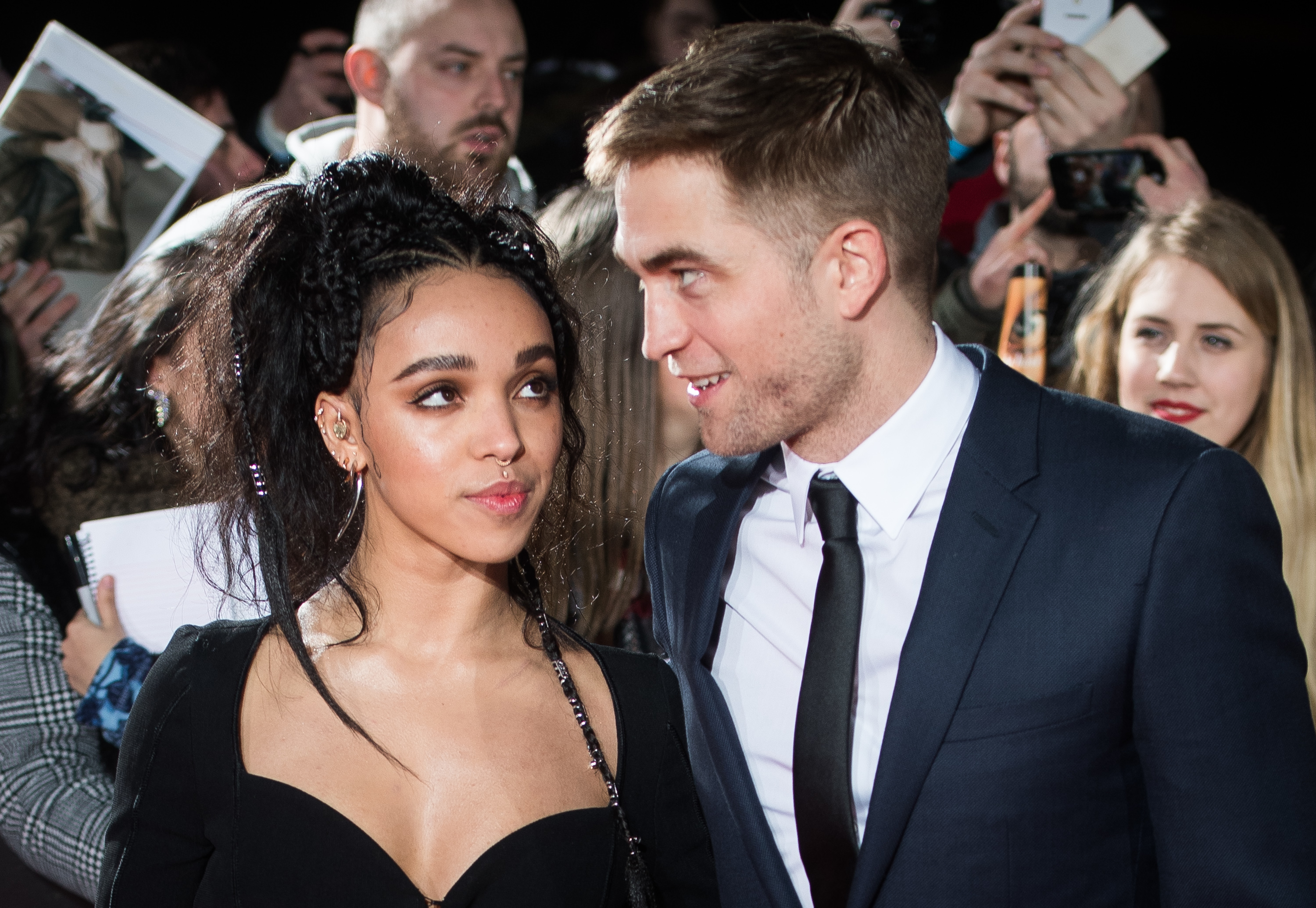 Close-up of FKA Twigs looking at Robert at a media event