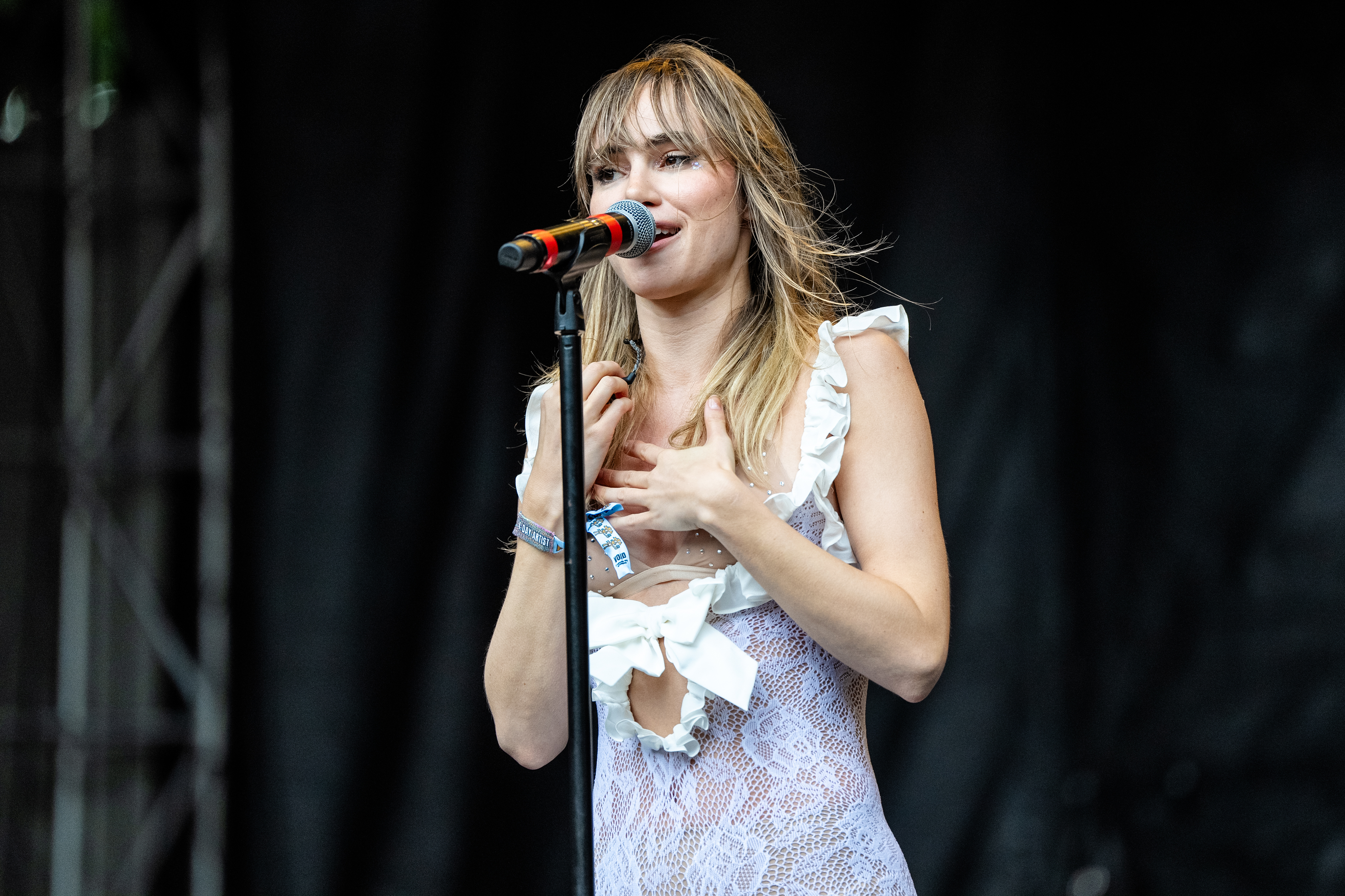 Suki standing at a microphone