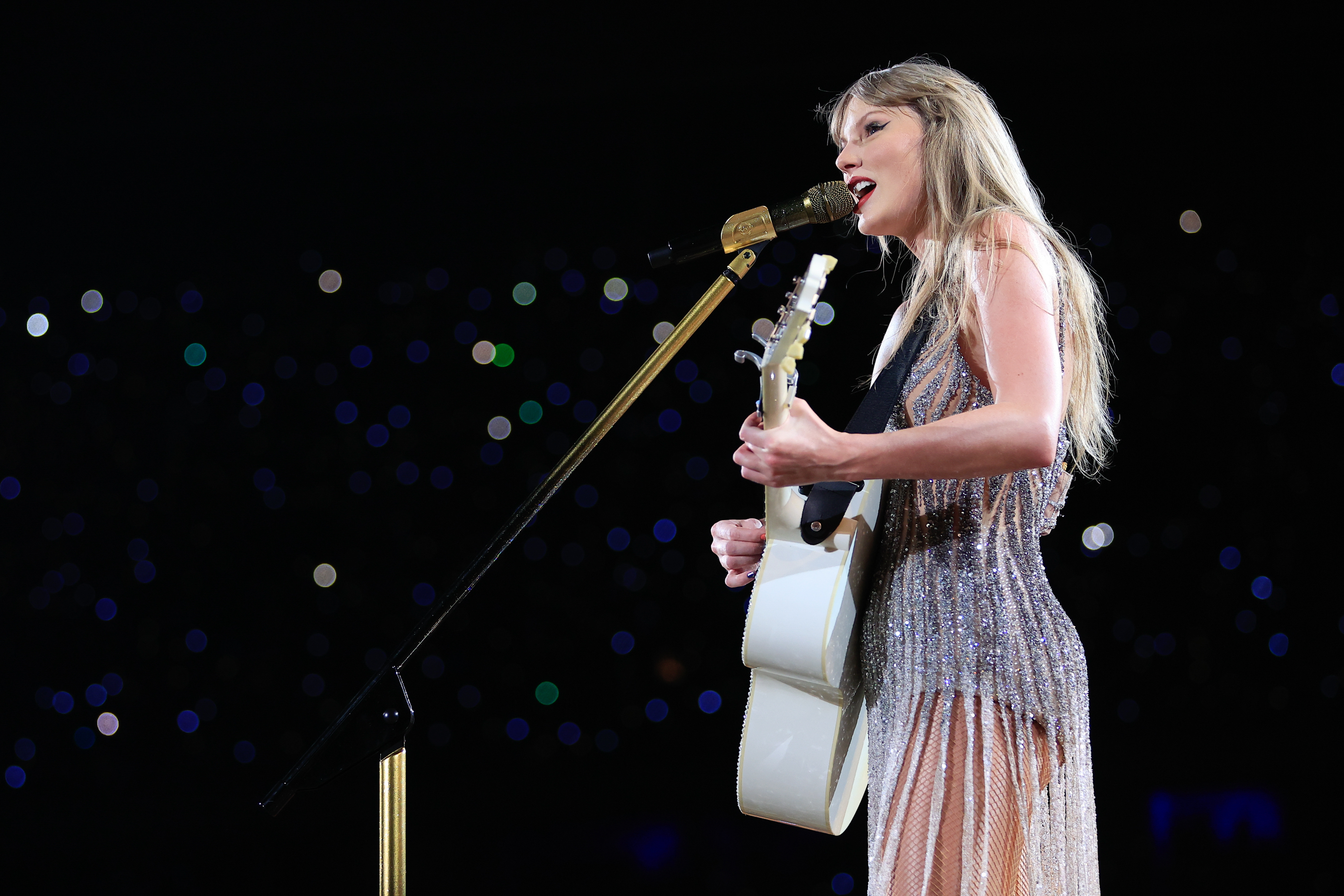 Close-up of Taylor performing onstage with a guitar