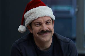Jason Sudeikis as Ted Lasso wearing a Santa hat