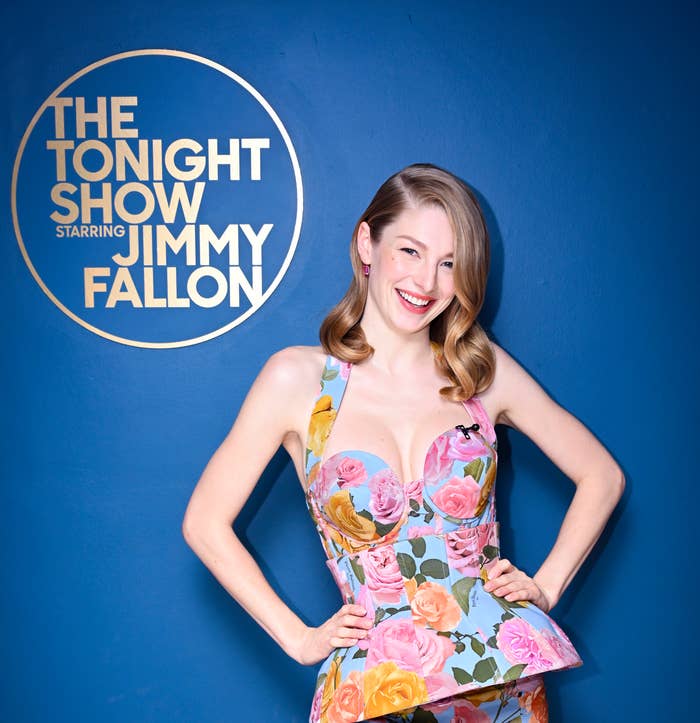 Hunter Schafer smiling as she poses by the logo for The Tonight Show Starring Jimmy Fallon