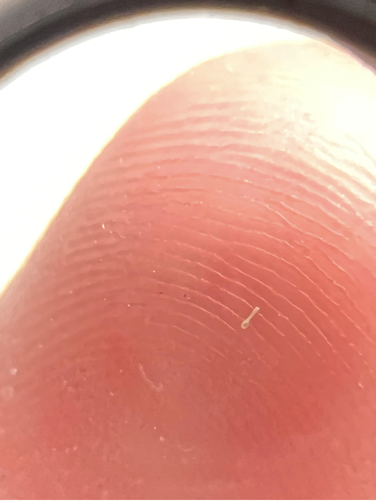 Close-up of a very tiny spoon on someone&#x27;s finger