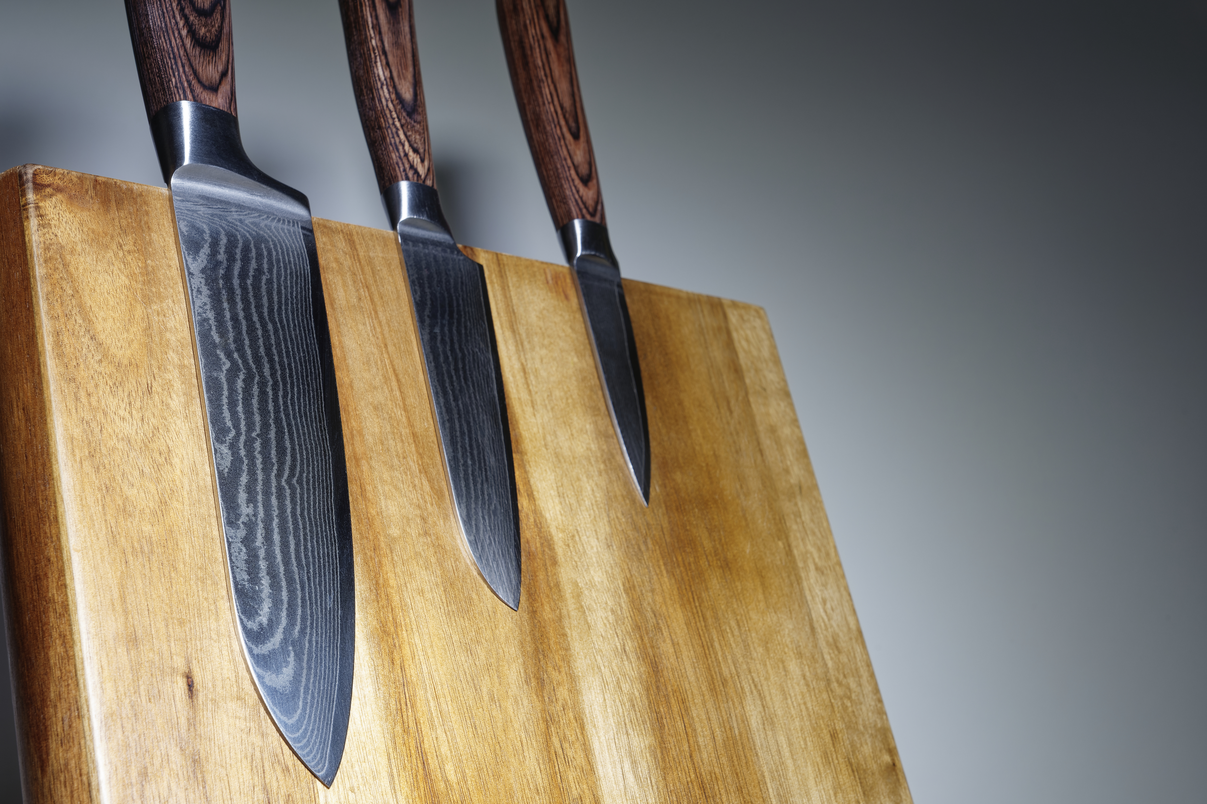 a set of gorgeous and very sharp kitchen knives on a butcher block