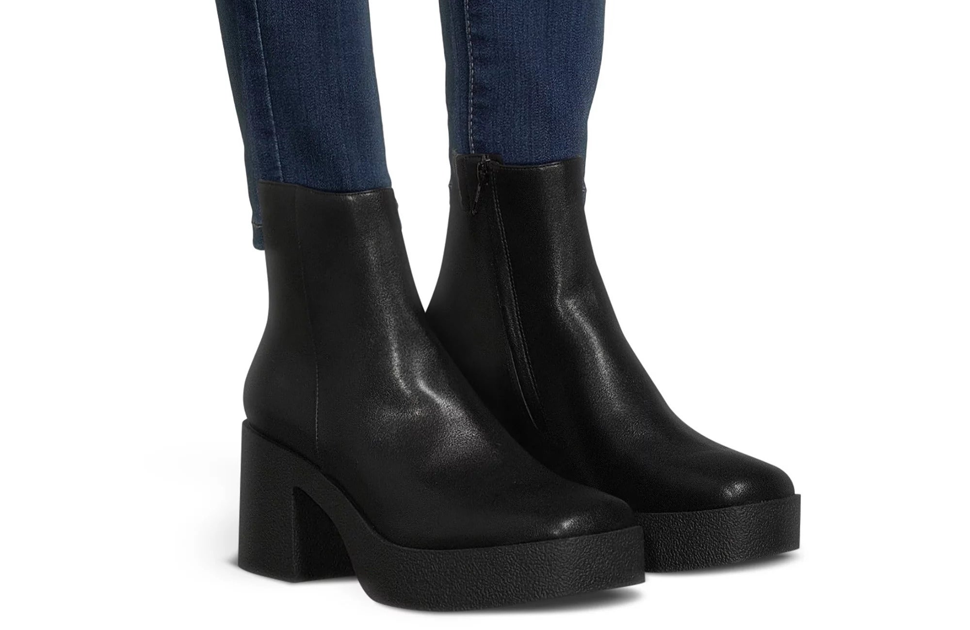 A model wearing the boots in black, which have zips on the side