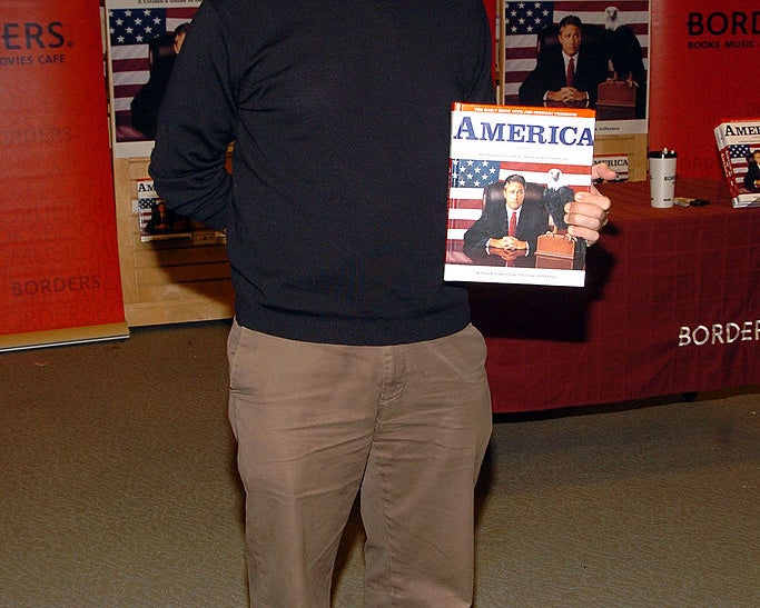 Jon Stewart holding his book