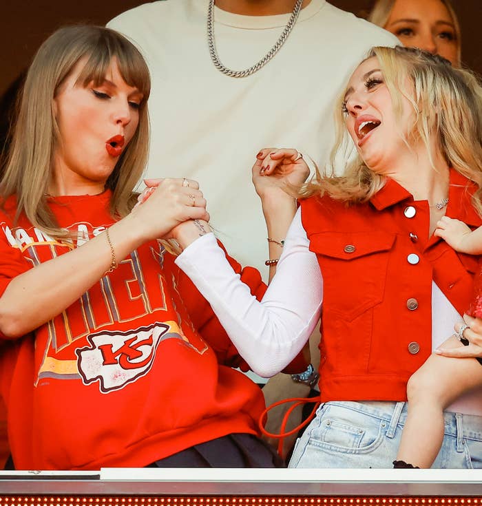 Taylor and Brittany clasping hands as they cheer