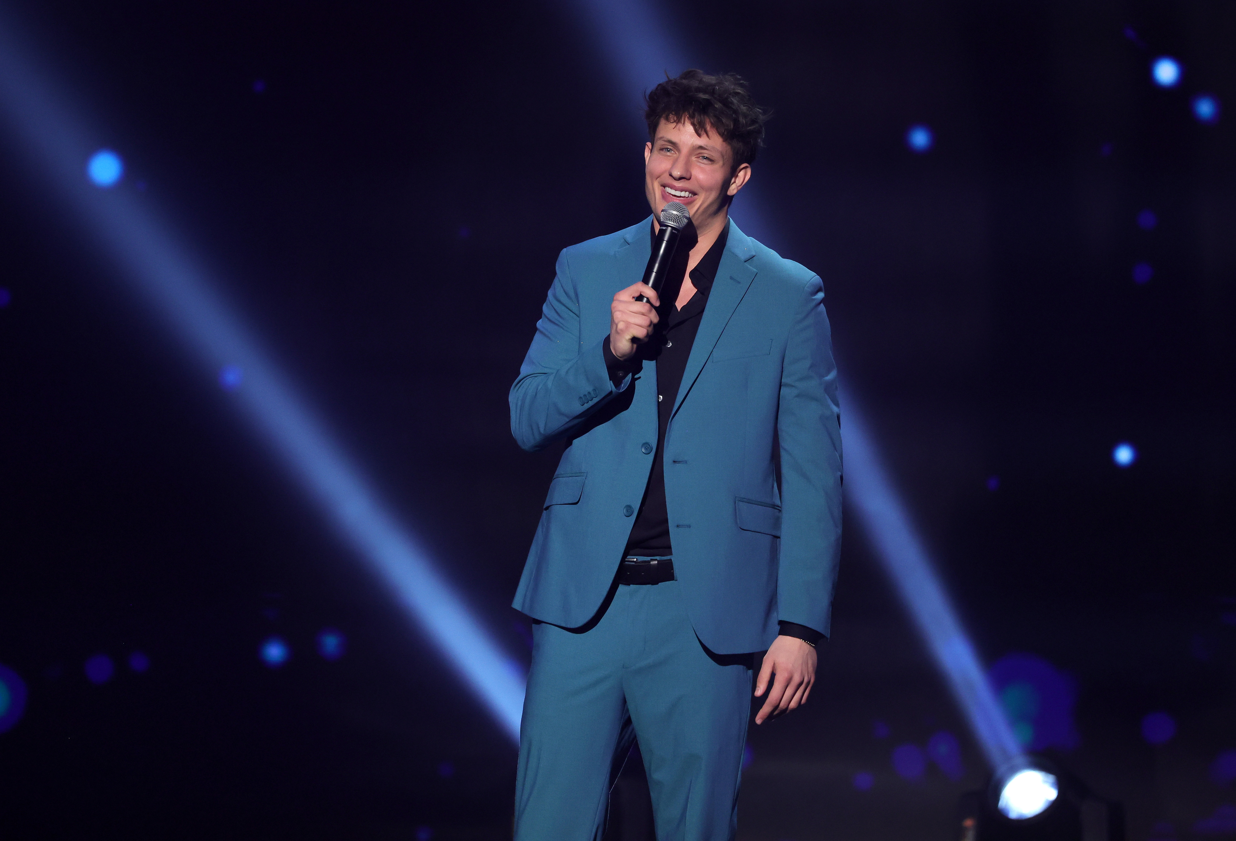 Matt Rife onstage in a suit