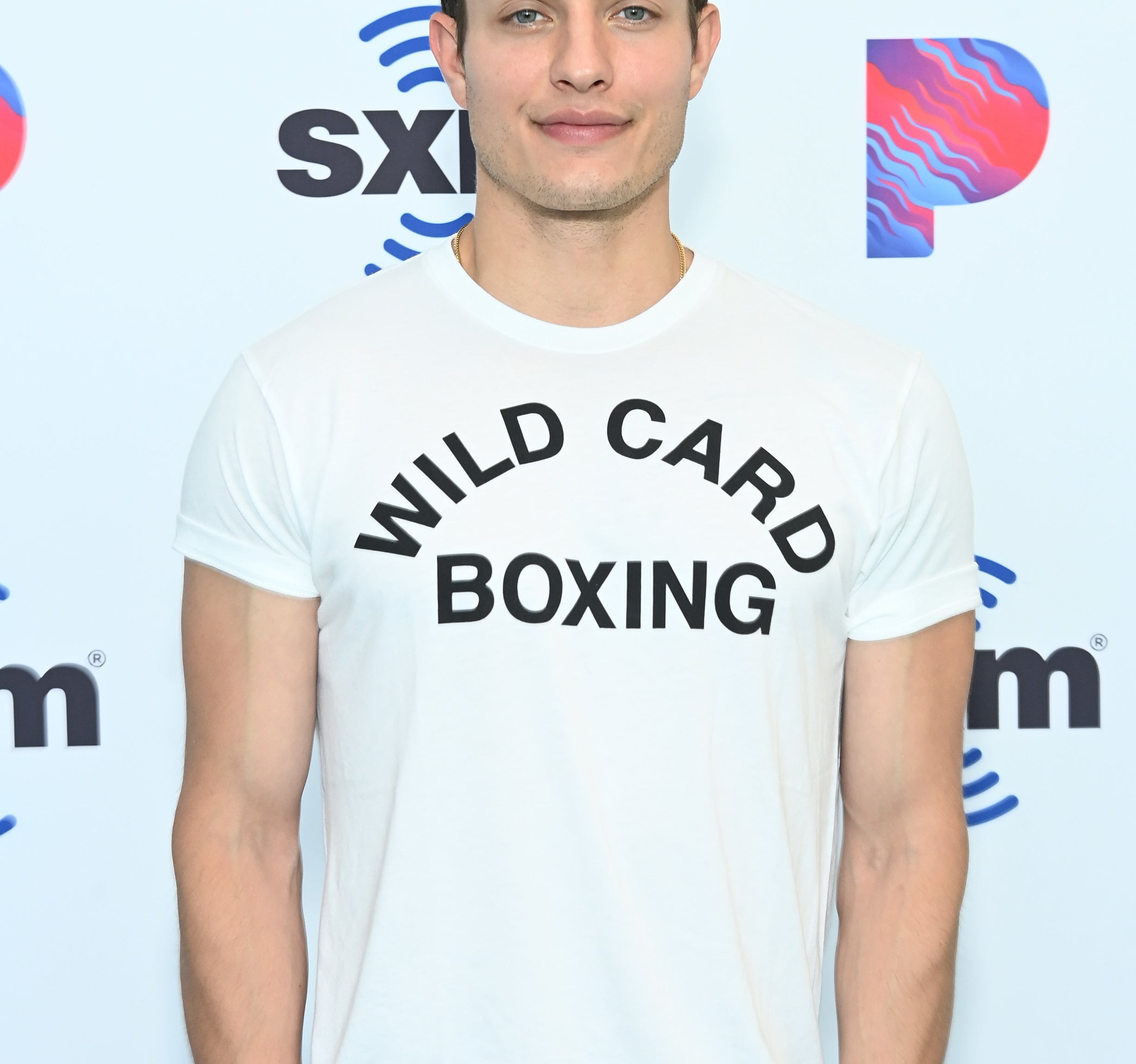 Closeup of Matt Rife on the red carpet wearing a baseball cap backwards and a t-shirt that says Wild Card Boxing