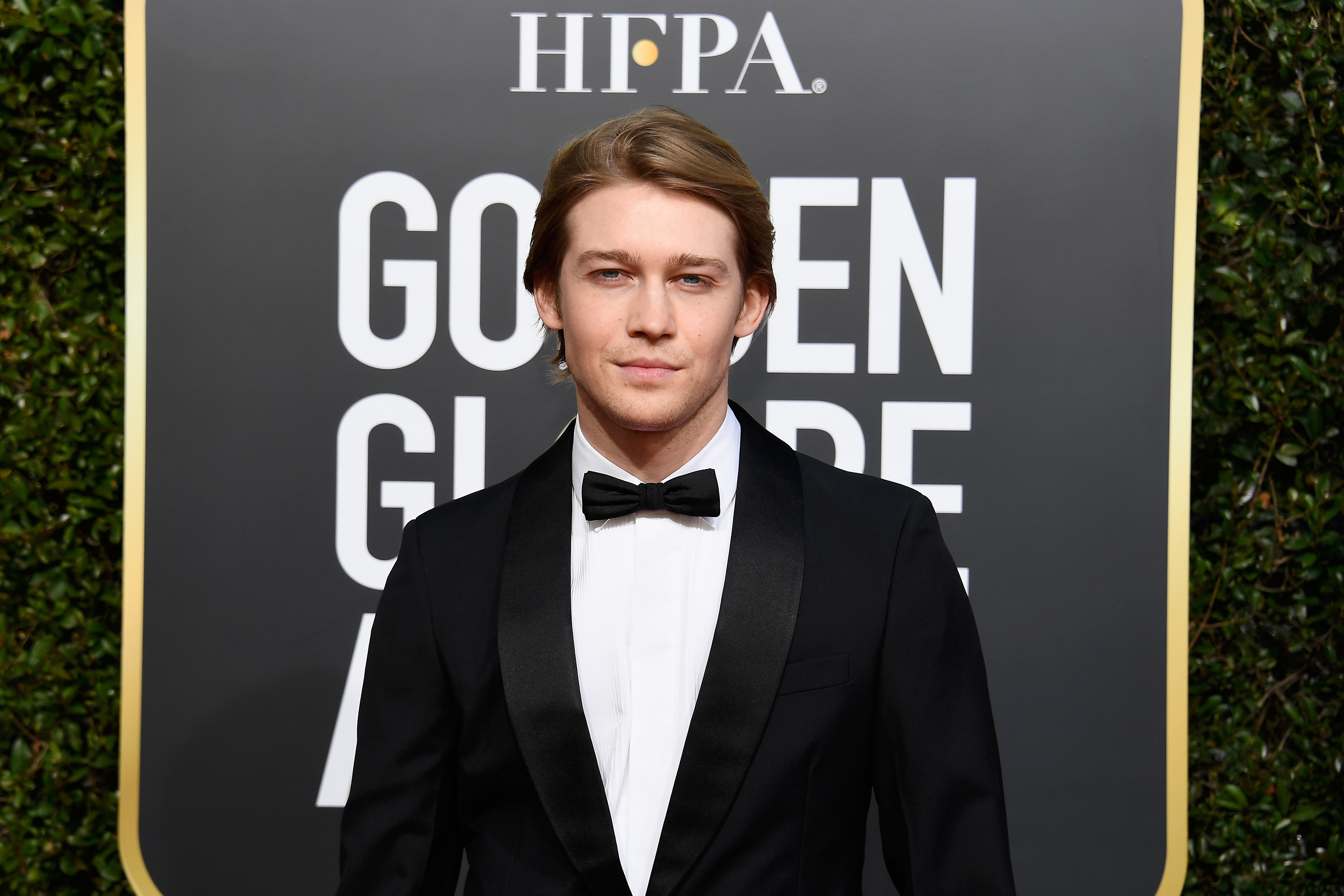 Closeup of Joe Alwyn at a media event wearing a tuxedo