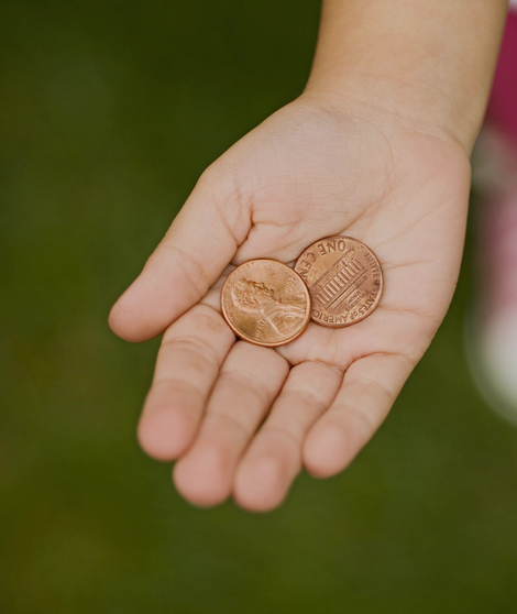 A hand holding some pennies