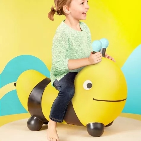 A child bounces on a bee toy