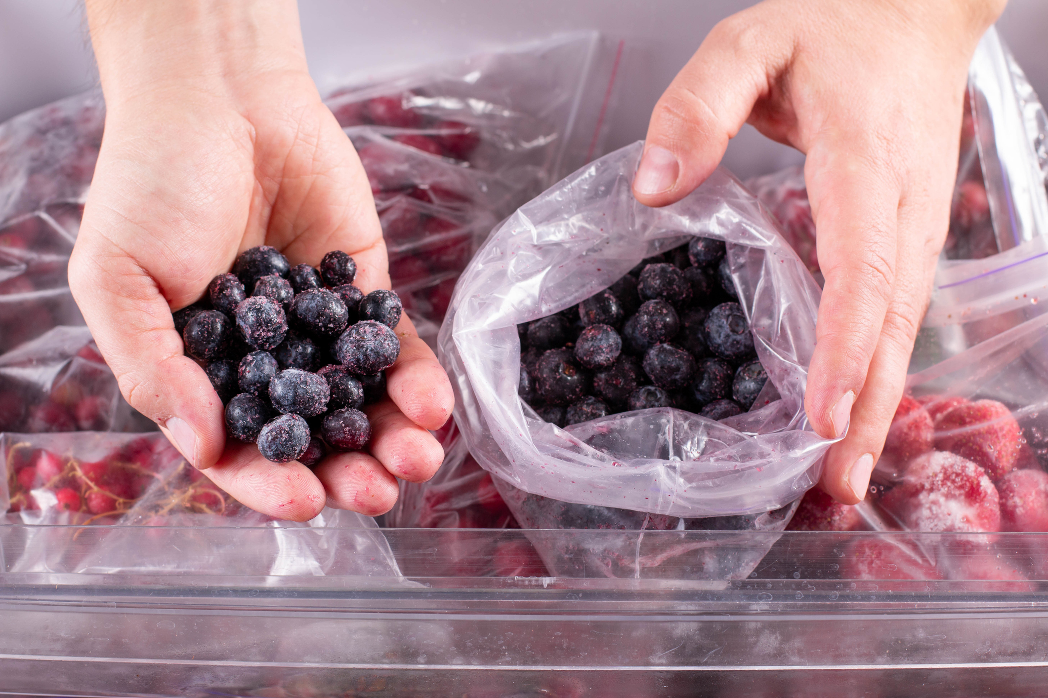 Someone pulling blueberries out of a bag