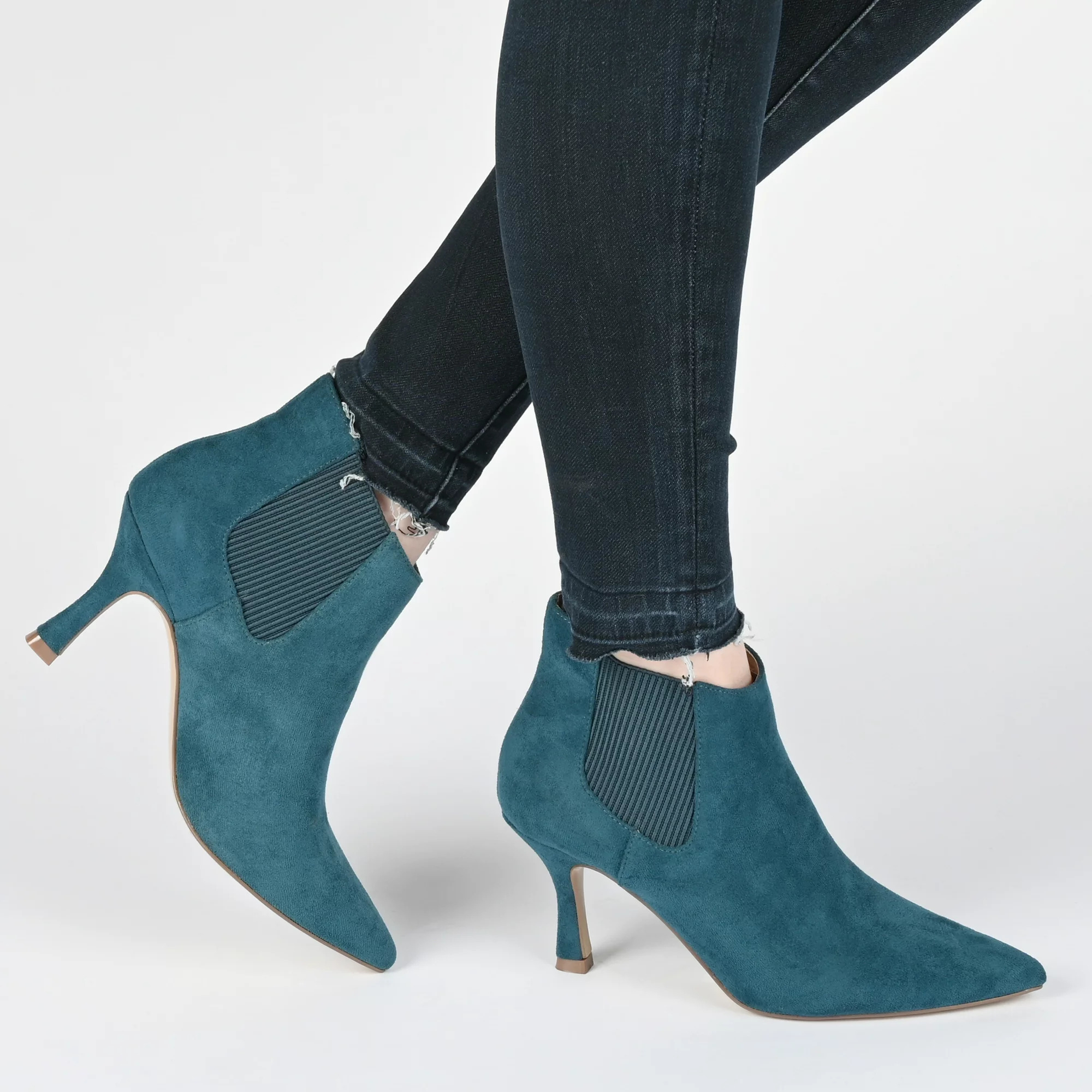 A model wearing the boots in teal