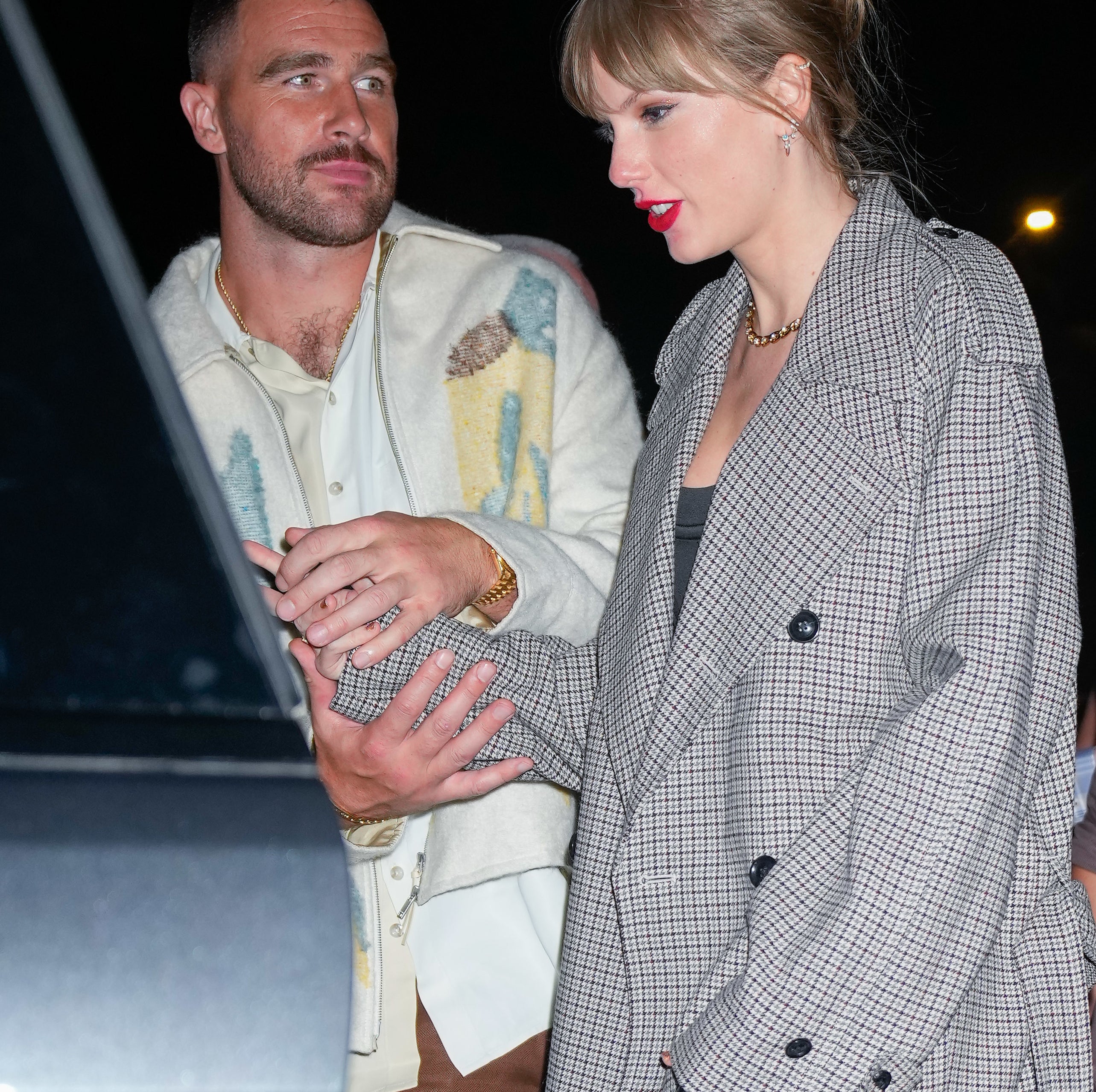 Closeup of Travis and Taylor holding hands as they get into a car