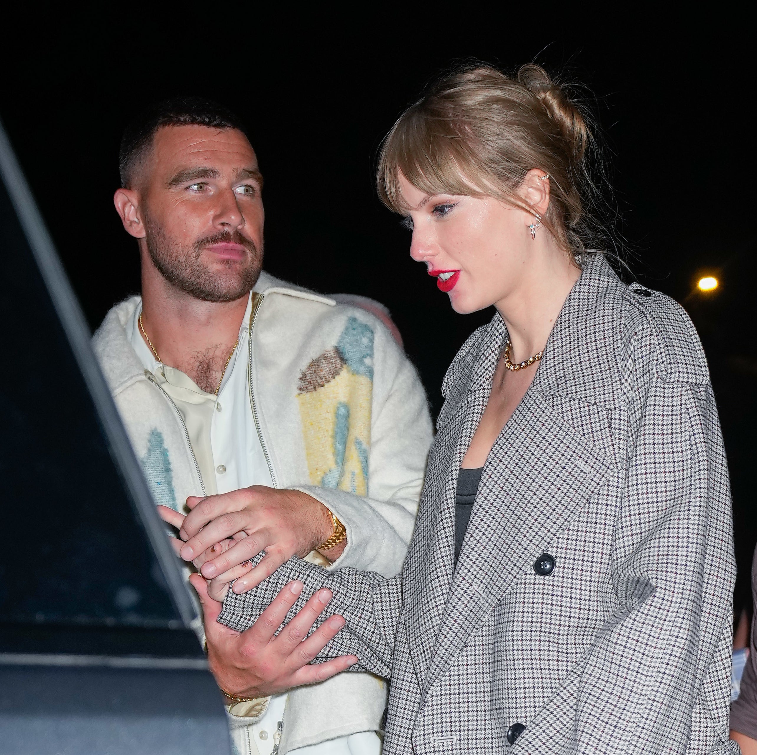 Closeup of Travis and Taylor holding hands as they get into a car