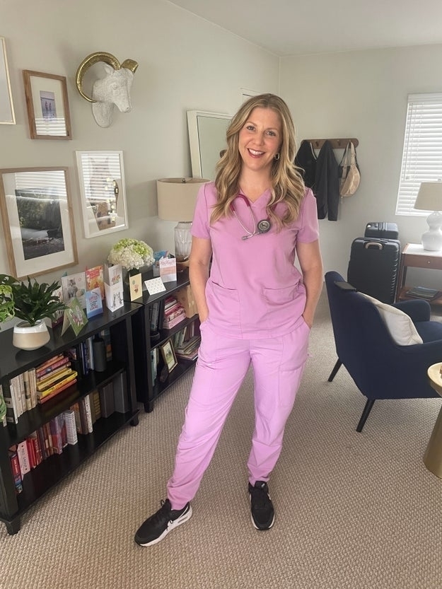 Julie smiling in her scrubs at her house