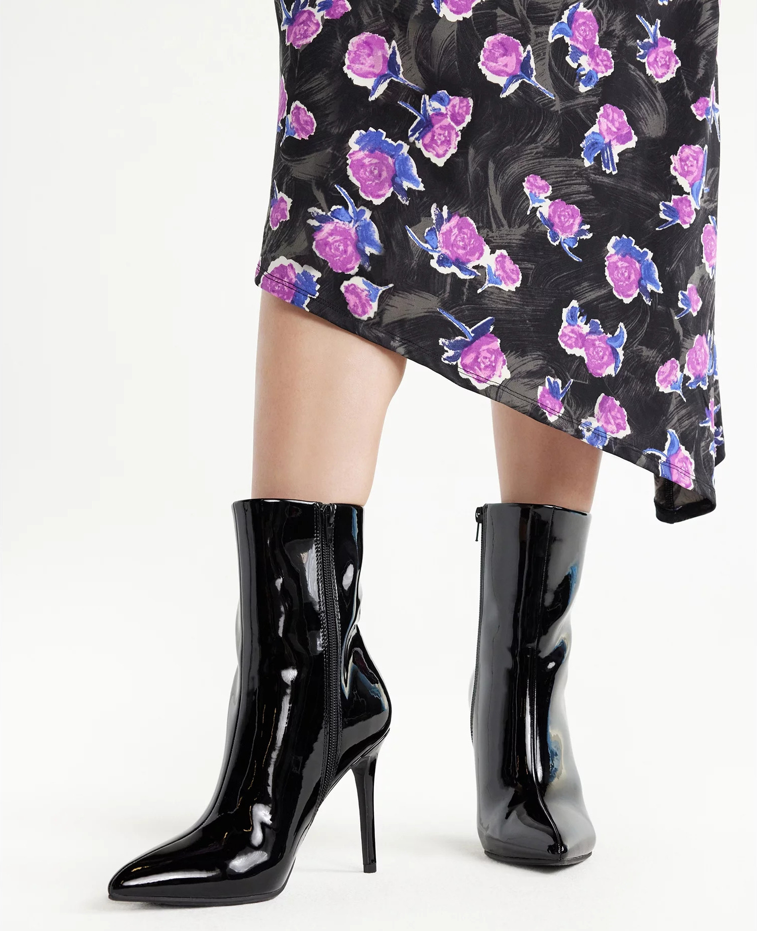A model wearing the midcalf boots in black patent