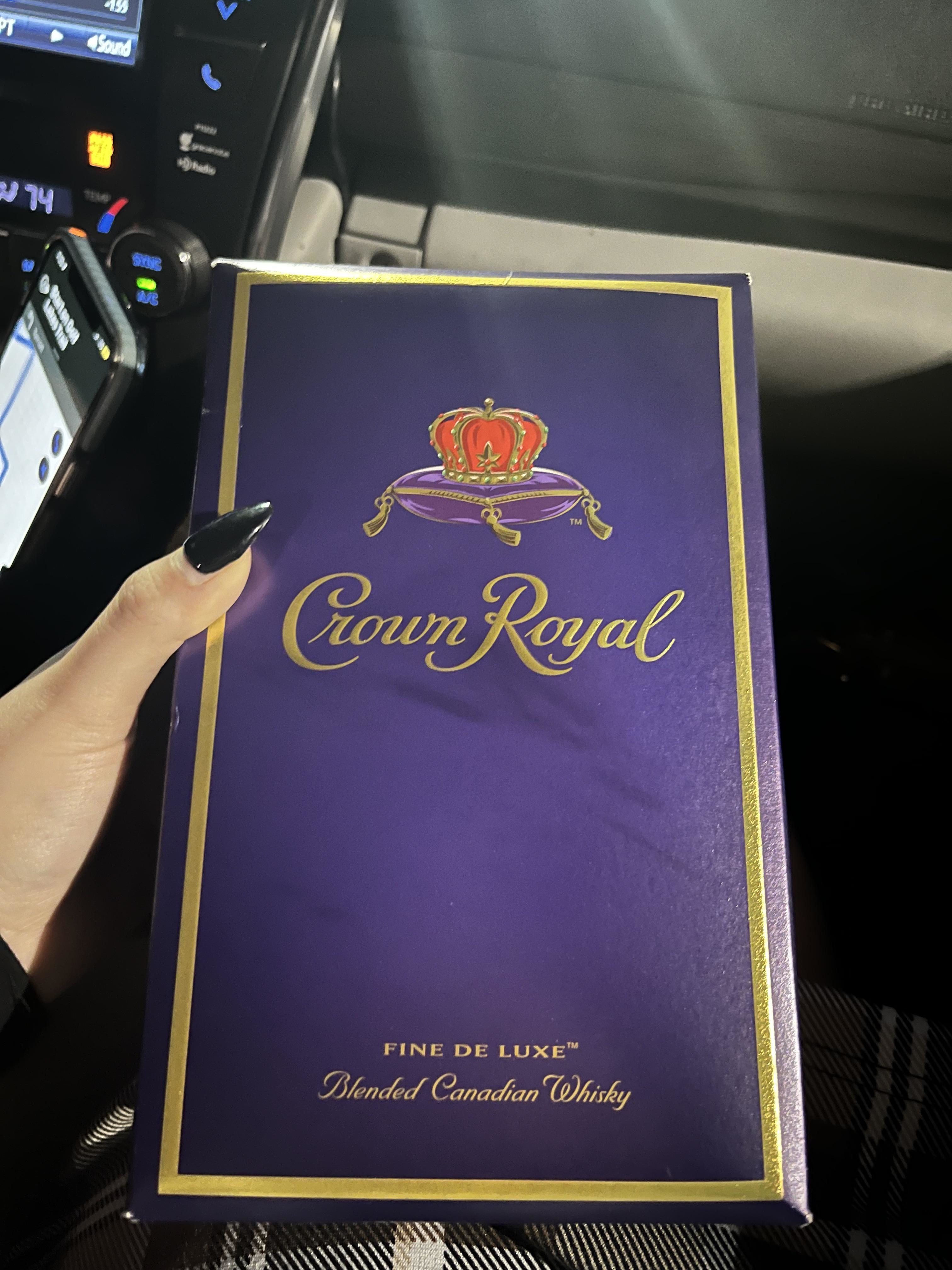 Person holding a Crown Royal Blended Canadian Whisky box