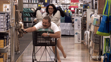 ron swanson being pushed in a shipping cart