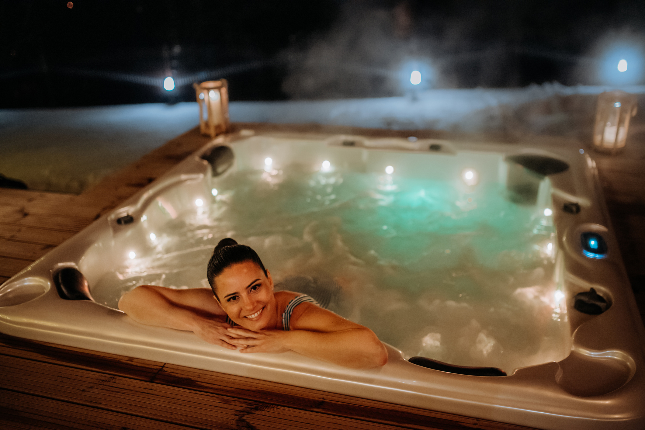 A smiling woman lounging in a hot tub
