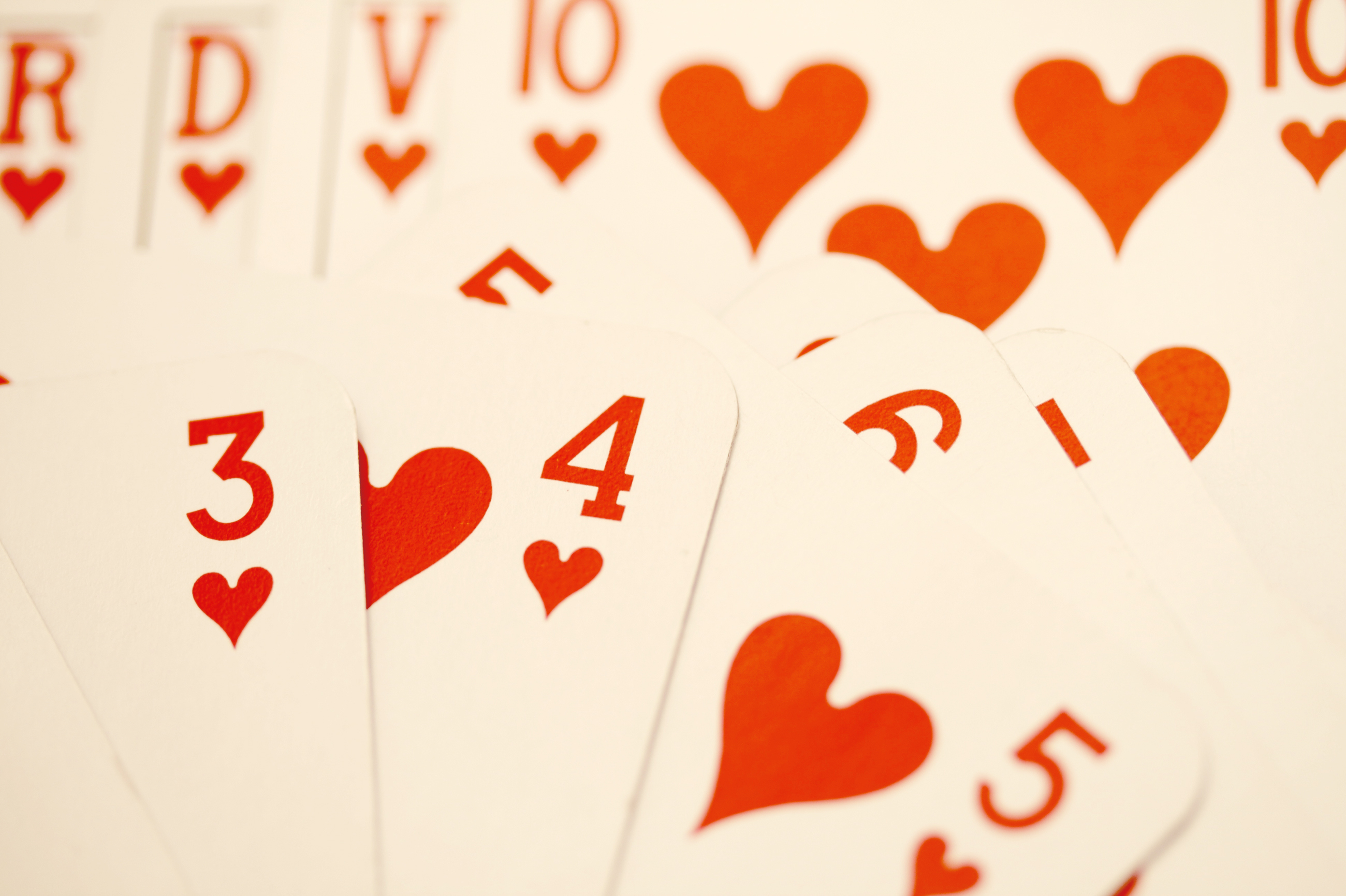 A spread-out deck of cards with a focus on the four of hearts