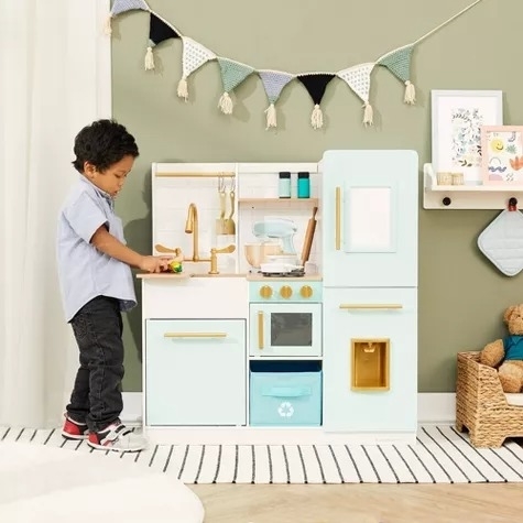 A toddler plays with a kitchen