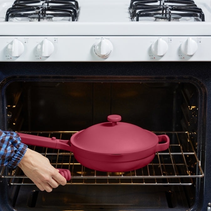 a berry colored always pan in an oven