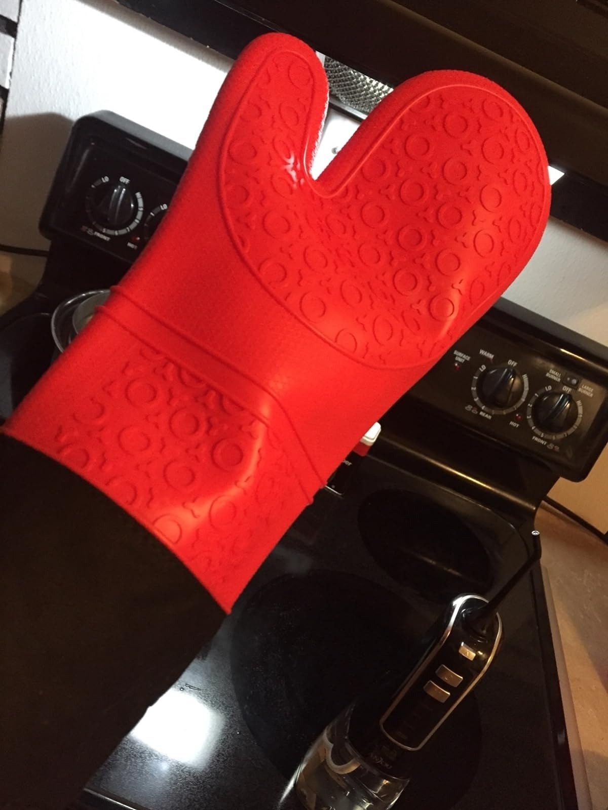 a reviewer wearing extra long red oven mitts