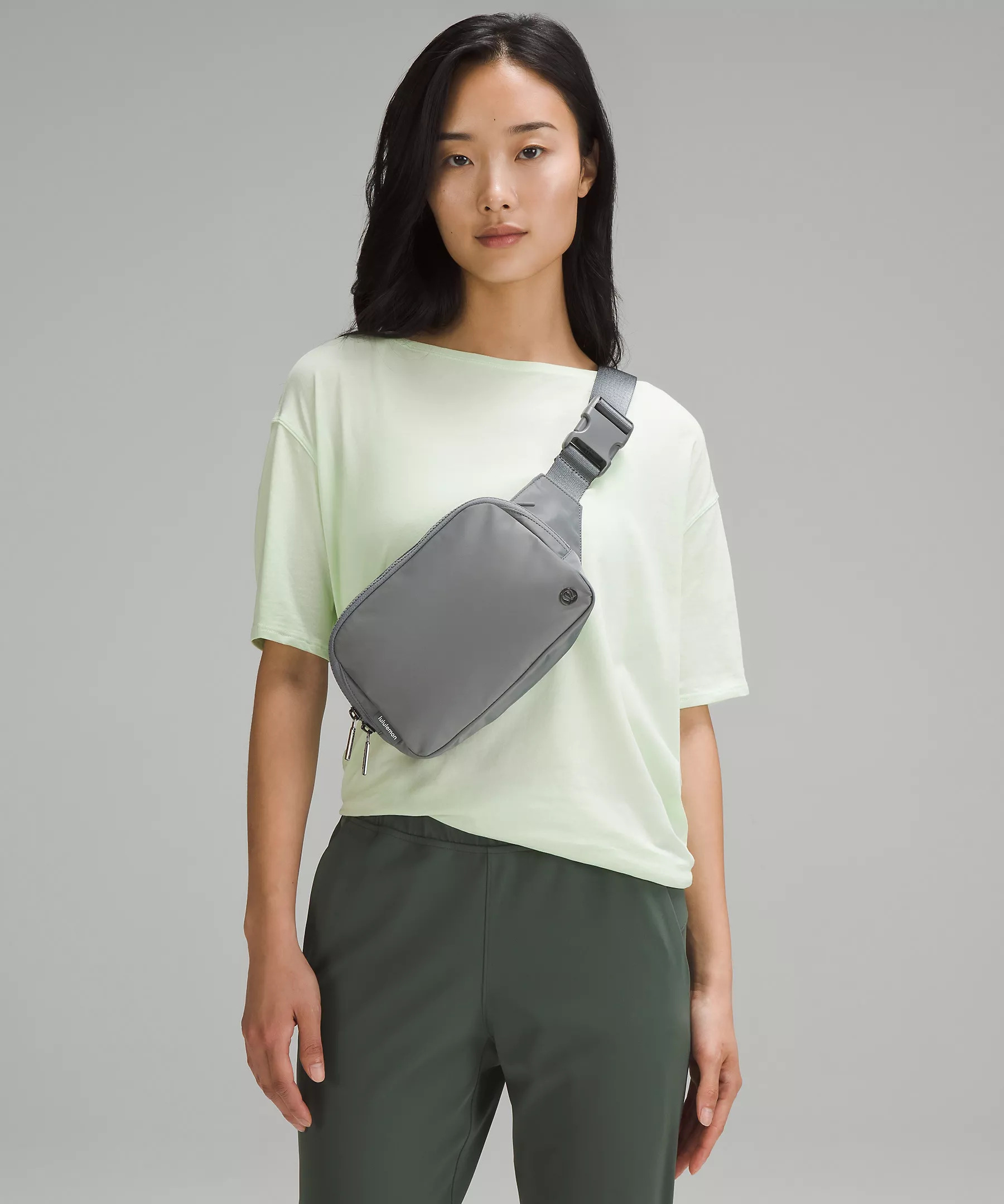 A model wearing the flat, rectangular shaped bag across the chest