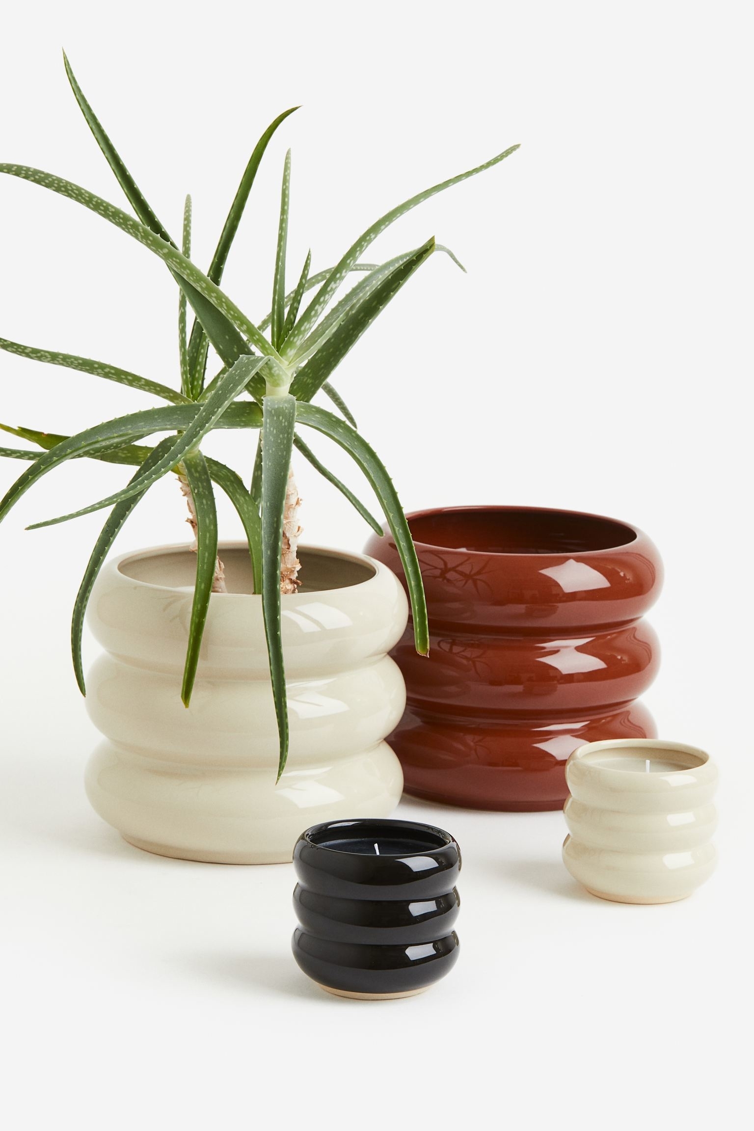 stoneware planters in beige, black, and red
