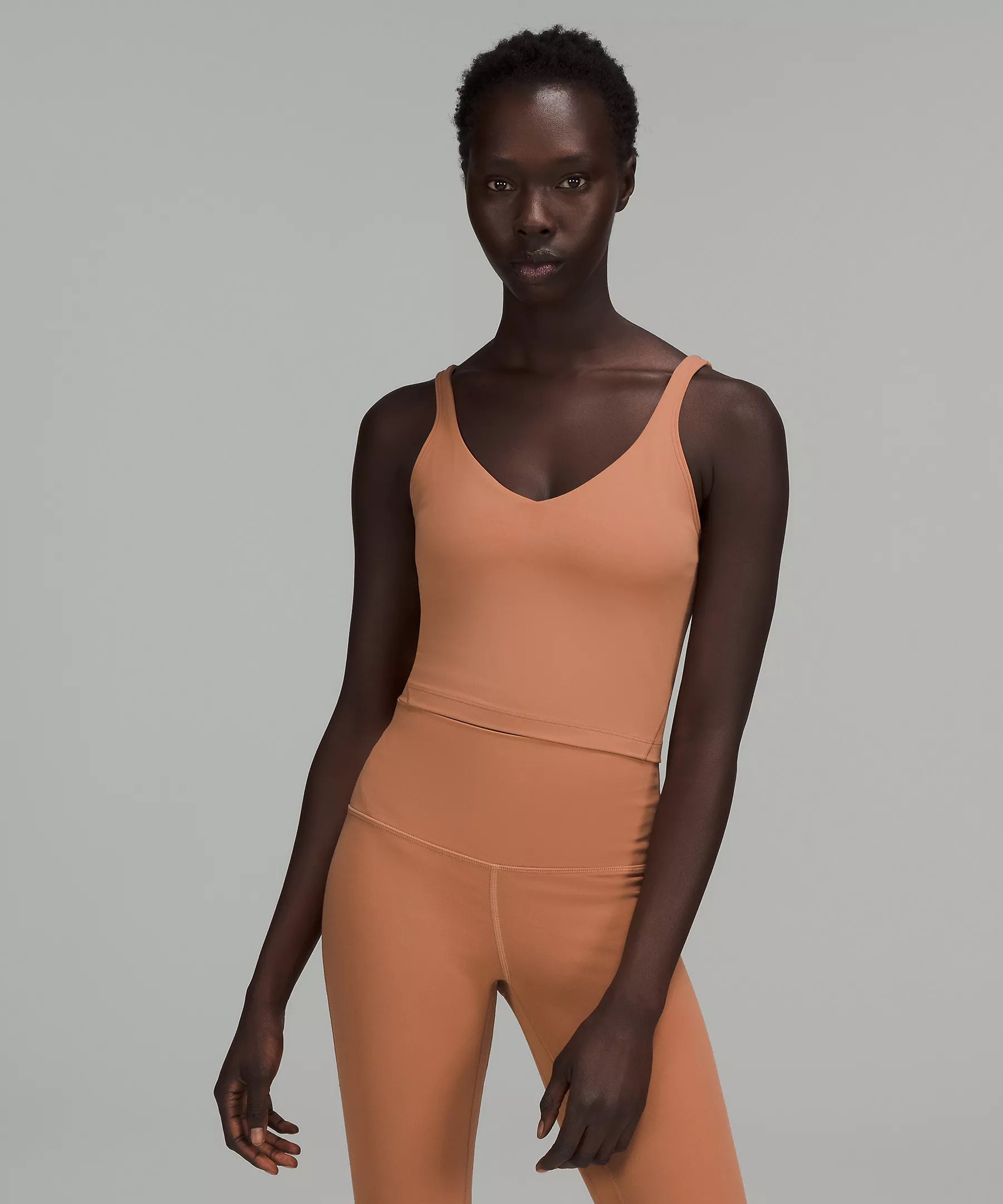 A model wearing the tank in muted orange color