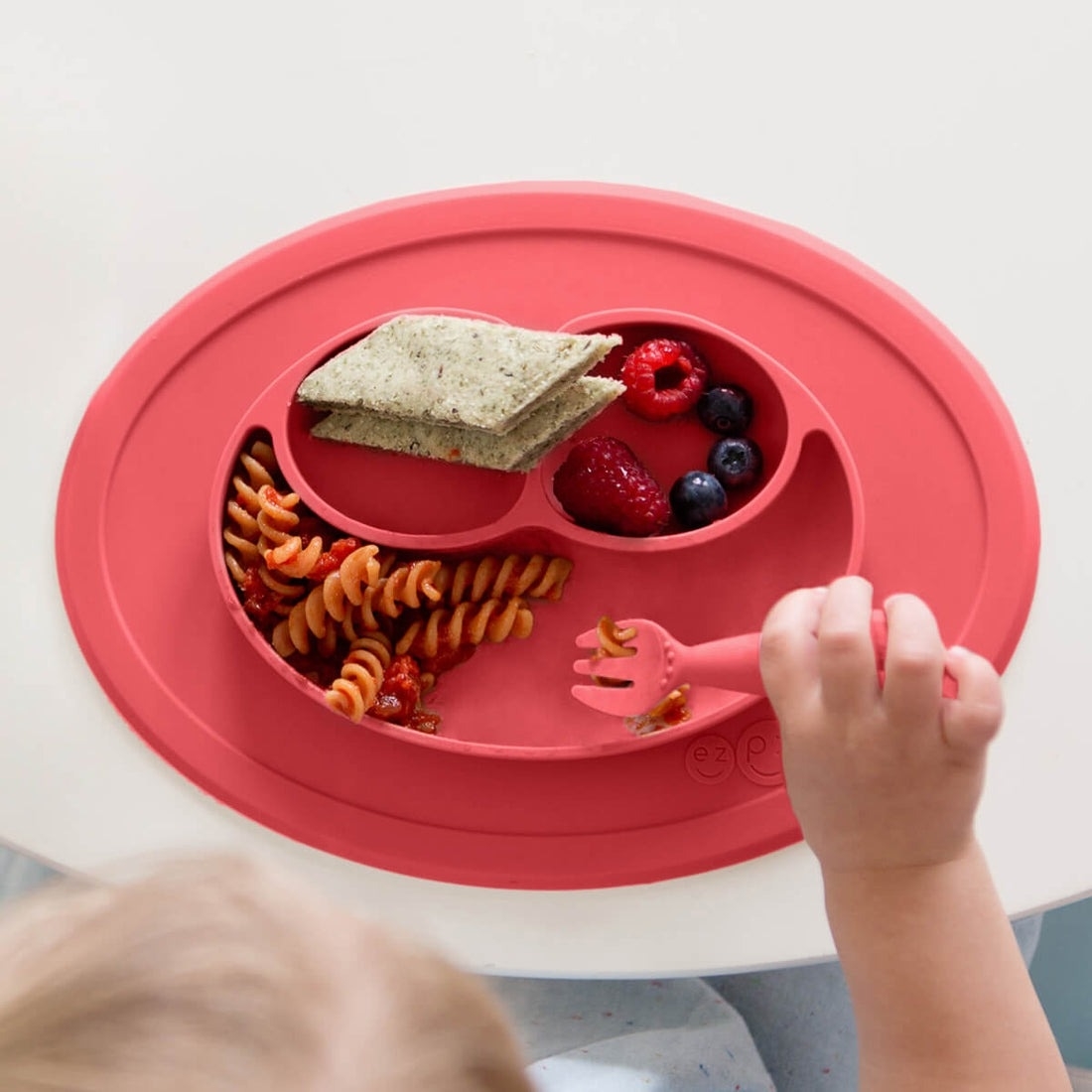 a child model scooping food out of the good mat with the included utensil
