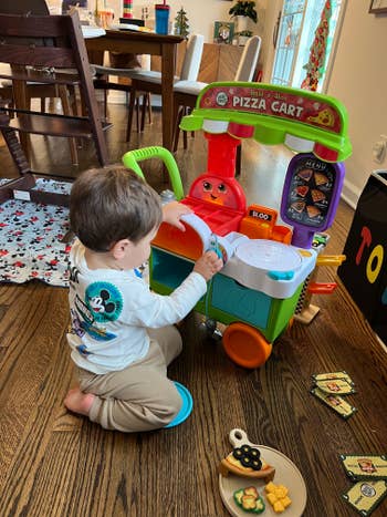 a buzzfeed editor's child playing with a pizza cart toy