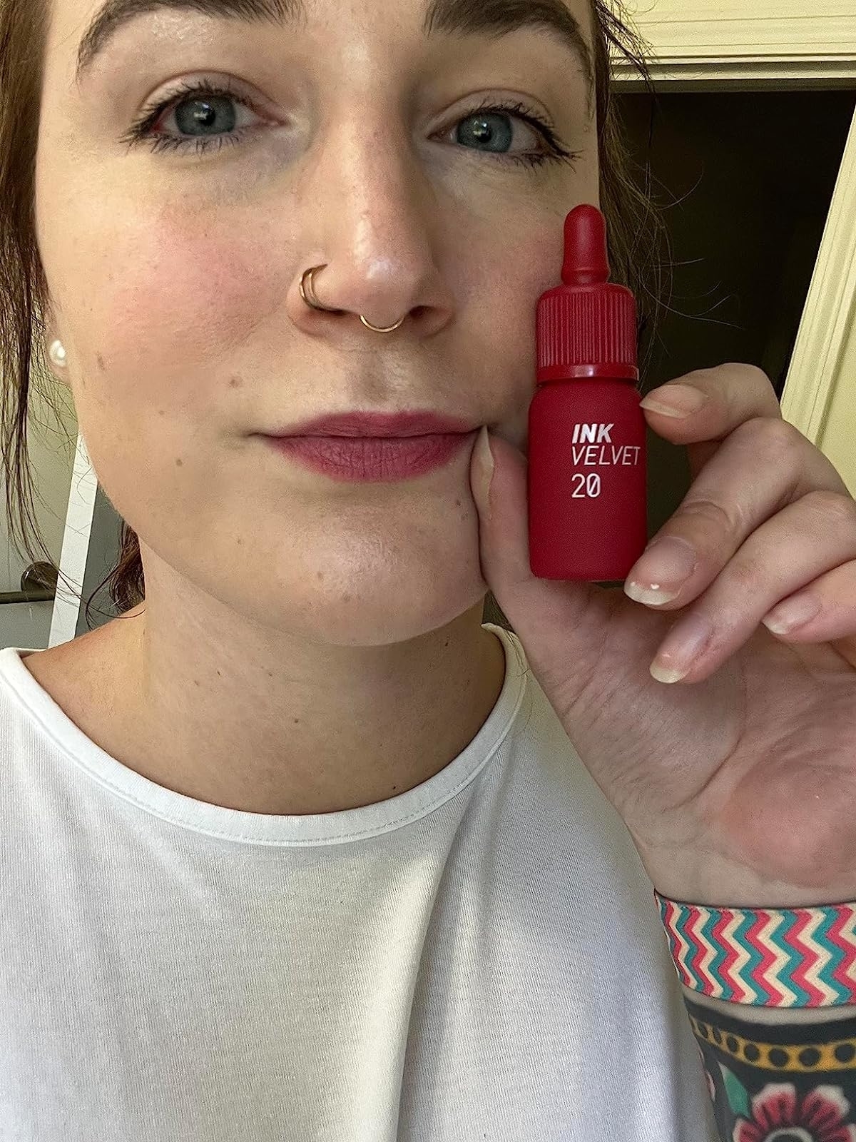 reviewer holding and wearing plum rose shade