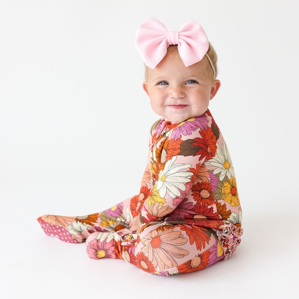 a floral one piece pajama set on a baby