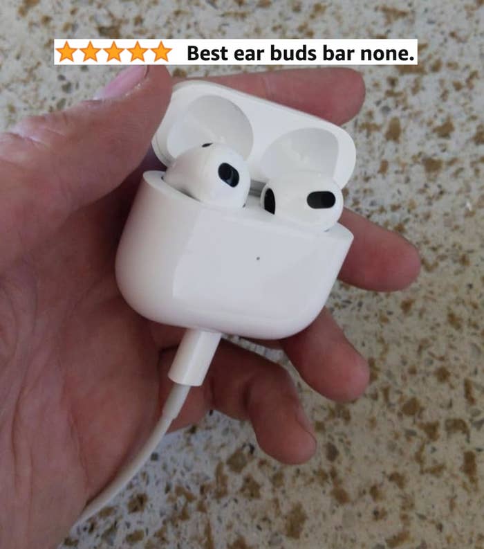 A hand holding a pair of wireless earbuds with a charging case. A 5-star rating and the text "Best ear buds bar none." are seen above the hand