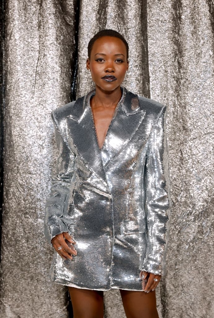 Lupita in a shiny suit-dress